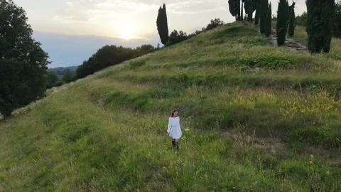 Drone View of Woman Walking Through Green Meadow at Sunset 스톡 동영상 337405292