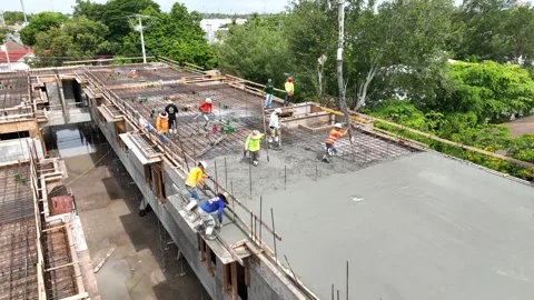 Drone view of workman pouring concrete with automatic pump tube on steel Stock Footage 245959877