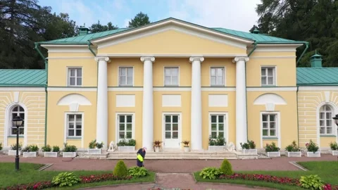 Drone view of yellow manor and vibrant flowerbeds Stock Footage 321896846