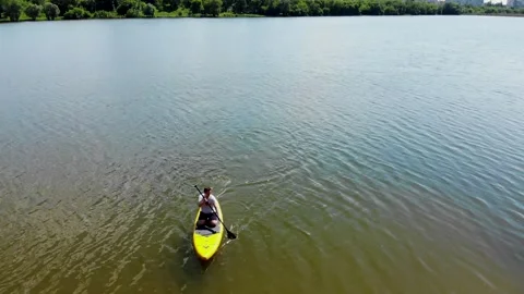 Drone view of a young guy paddling a SUP board Stock Footage 247438682