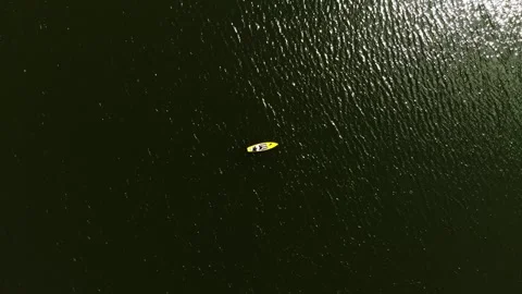 Drone view of a young guy paddling a SUP board Stock Footage 247440486