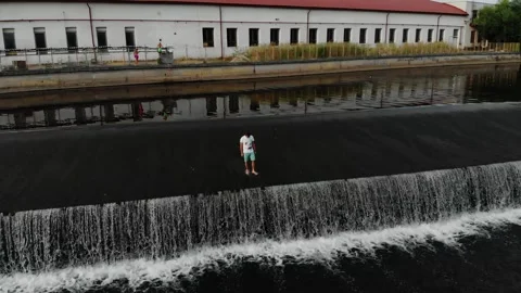 A drone view of a young guy standing on the dam in the Czech Republic Stock Footage 254918185