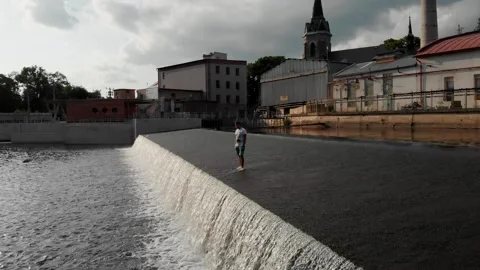 A drone view of a young guy standing on the dam in the Czech Republic Stock Footage 254918187