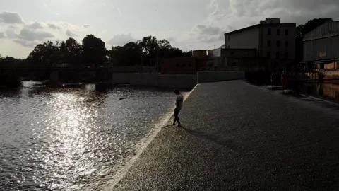 A drone view of a young guy standing on the dam in the Czech Republic Stock Footage 254918301