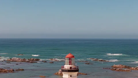 Drone Viewing Sea, Waves, Beach, Sand, and Horizon, Descending to Reveal Lightho Stock Footage 306357516