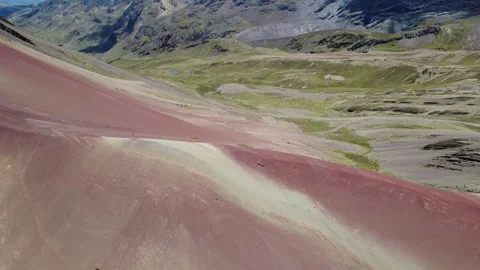 Drone_sinking_flight_red_mountain_green_valley_in_the_back Stock Footage 327173969