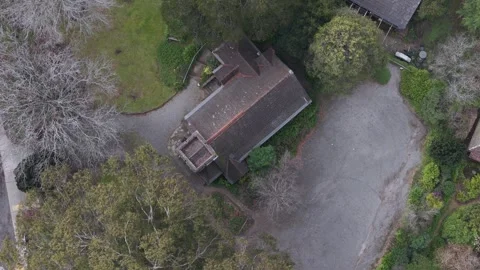 Drone's bird's-eye view of a historic church with a tower surrounded by woods Video stock 341904404