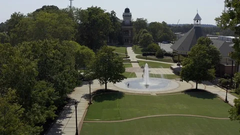Drone's eye view of a young African American girl playing in a water fountain Stock Footage 115686285