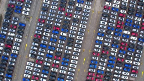 Drones flying above factory parking lot, new cars unsold Stock Footage 210794518