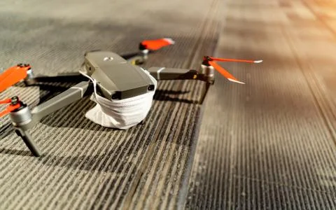 Drones forbidden concept: Unfolded drone covered by medical face mask. No fly Stock Photos