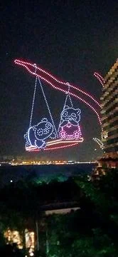 Drones in THE NIGHT SKY animating two panda bears swinging on a tree Stock-Fotos