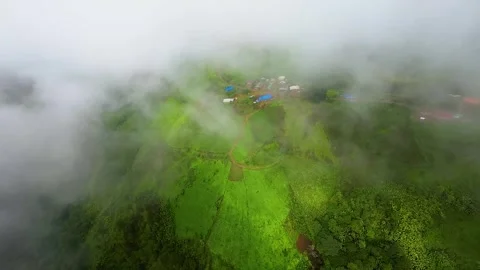 Drones shoot green hills and farms above the clouds Stock Footage 313346813