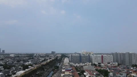 The drone's view panning from the right records the city against a clear sky Stock Footage 260865507