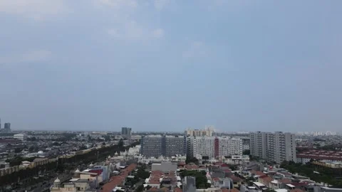 The drone's view panning from the right records the city against a clear sky Stock Footage 260865516