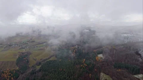 Drone's winter journey above the clouds, unveiling snow-blanketed mountains.. Video stock 258567132