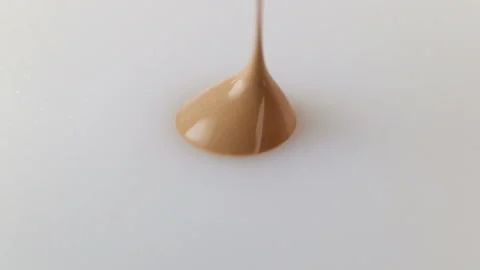 A drop of beige liquid Foundation extreme close-up, real time, white background, Stock Footage 129278267