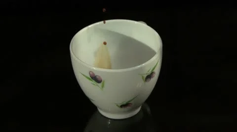 A drop of black coffee slowly drips into a full white cup 스톡 동영상 10775505