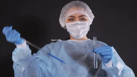 A drop of blue liquid falls into a transparent vessel from a glass tube of a Stock Footage 127654559