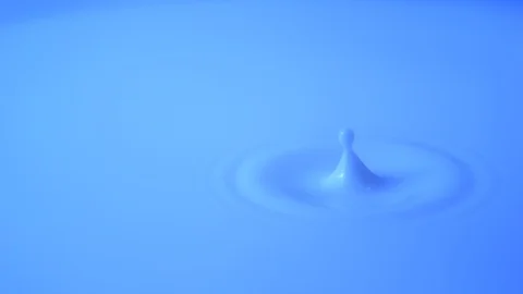 Drop of blue paint falling in slow motion filmed with high speed camera