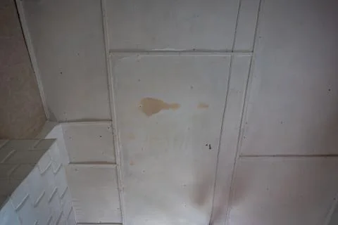 Drop ceiling with visible water damage, stains, and discoloration across mult Stock Photos