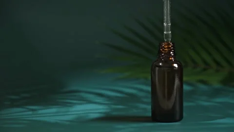 Drop clear liquid, oil, serum or tincture dripping pipette in neck bottle on Stock Footage 240396160