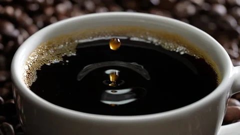Drop of coffee falling into coffee cup. Slow motion. Video stock 177562971