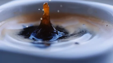 Drop of coffee falls into the filled cup Vídeo Stock 105650250