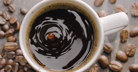 Drop of coffee slowly falls into a cup with coffee, top view, close-up. Stock Footage 149732397