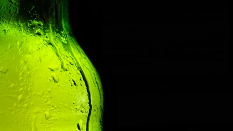 Drop of condensate drips on beer bottle glass 4k close-up slow-motion video. Stock Footage 155797883