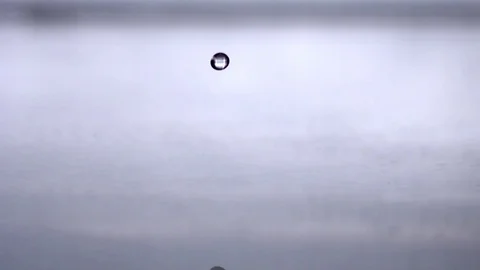 Drop creating a splash and ripples after falling into the water in slow motion Stock Footage 81231591