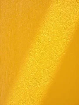Drop diagonal shadow overlay on yellow concrete wall texture background. Stock Photos
