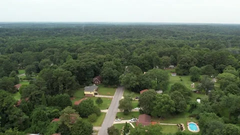 Drop down aerial flight showing green trees street neighborhood Stock Footage 170572219