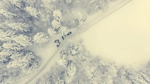 Drop down of a road through snow covered forest. Stock Photos