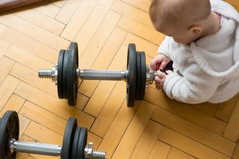 Drop down view of a child playing with a set of barbells. Stock Photos