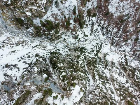 Drop down view of a mountain river flowing through winter forest. Stock Photos
