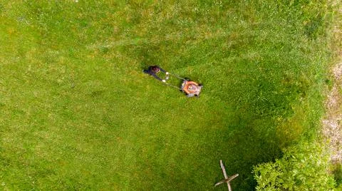 Drop down view of a person mowing lawn. 写真素材