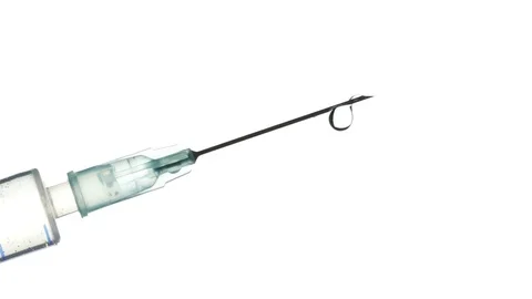 A drop dripping from the syringe needle on a white background, closeup Video stock 84883836