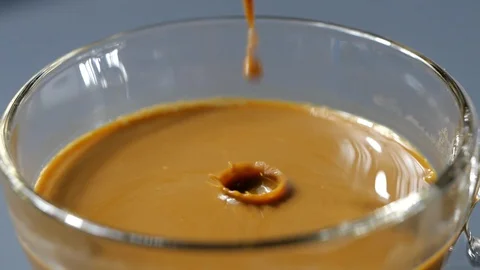 Drop of espresso falls into the filled Cup from the coffee machine Stock Footage 113595593