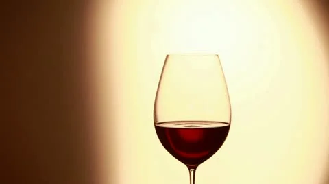A drop falling into a glass of red wine Stock Footage 24668752