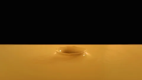 Drop falling in slow motion in orange paint and making beautiful crown splash Stock Footage 85877062