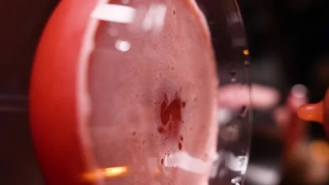 A drop falls into a glass with a red alcoholic cocktail making Stock Footage 263184959