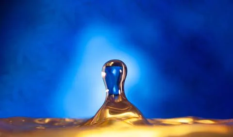 A drop falls on the surface of the water . Stock Photos