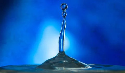 A drop falls on the surface of the water . Stock Photos