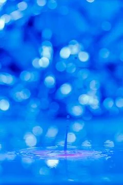 A drop falls into a thick liquid with a blue-pink background. Abstract colorful Stock Photos