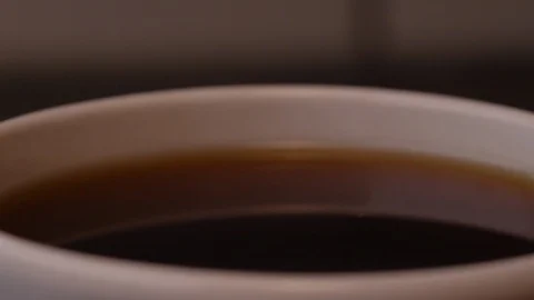 A drop into a filled cup of coffee in slow motion Stock Footage 127227318