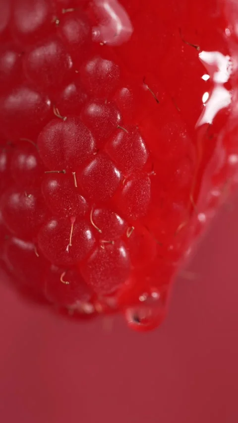 A drop flows down a raspberry berry, macro Stock Footage 308931120
