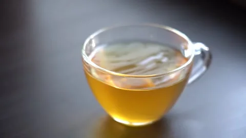 A Drop of Green Tea Falls into a Transparent Cup Stock Footage 151474039