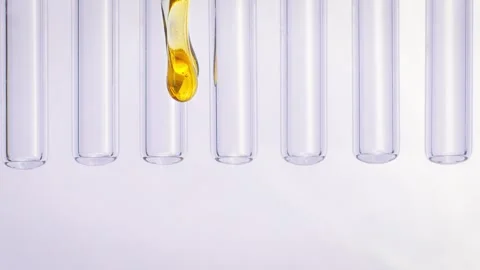 A drop of honey flows down glass tubes Stockbeeldmateriaal 258322673