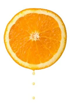 Drop of juice falling from orange half isolated Stock Photos