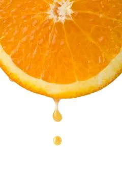 Drop of juice falling from orange half isolated Stock Photos